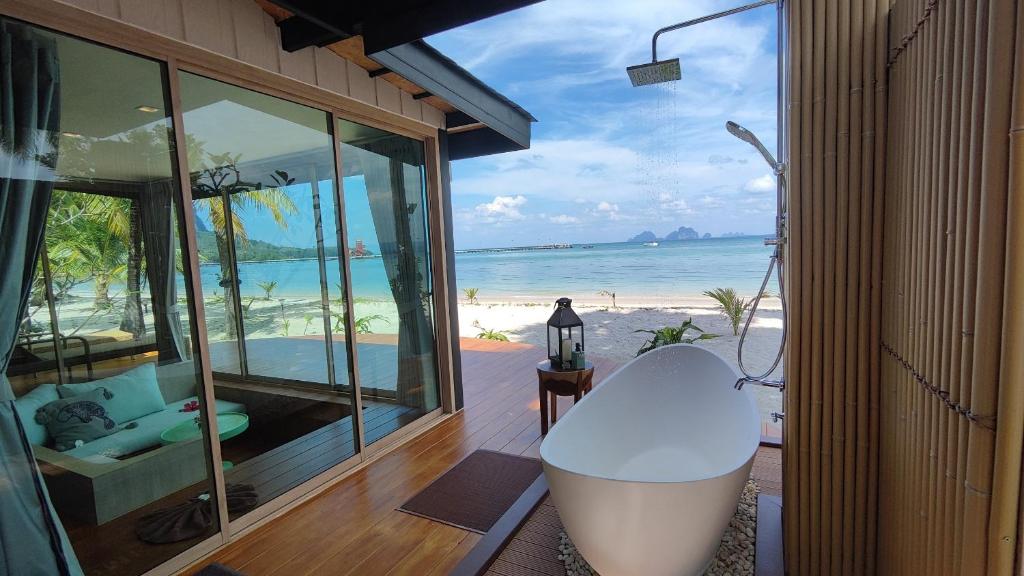 a room with a tub and a view of the beach at Koh Mook Sivalai Beach Resort in Ko Mook