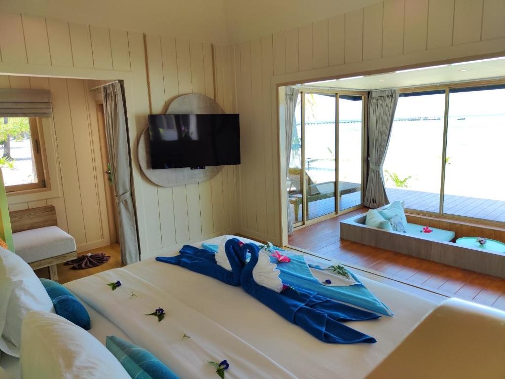 a bedroom with a large bed with a tv on the wall at Koh Mook Sivalai Beach Resort in Ko Mook