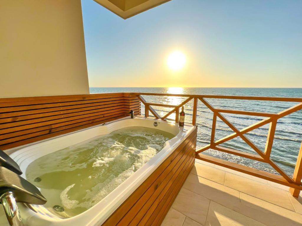 a jacuzzi tub with the ocean in the background at Caribbean Escape Lodge in San Silvestre