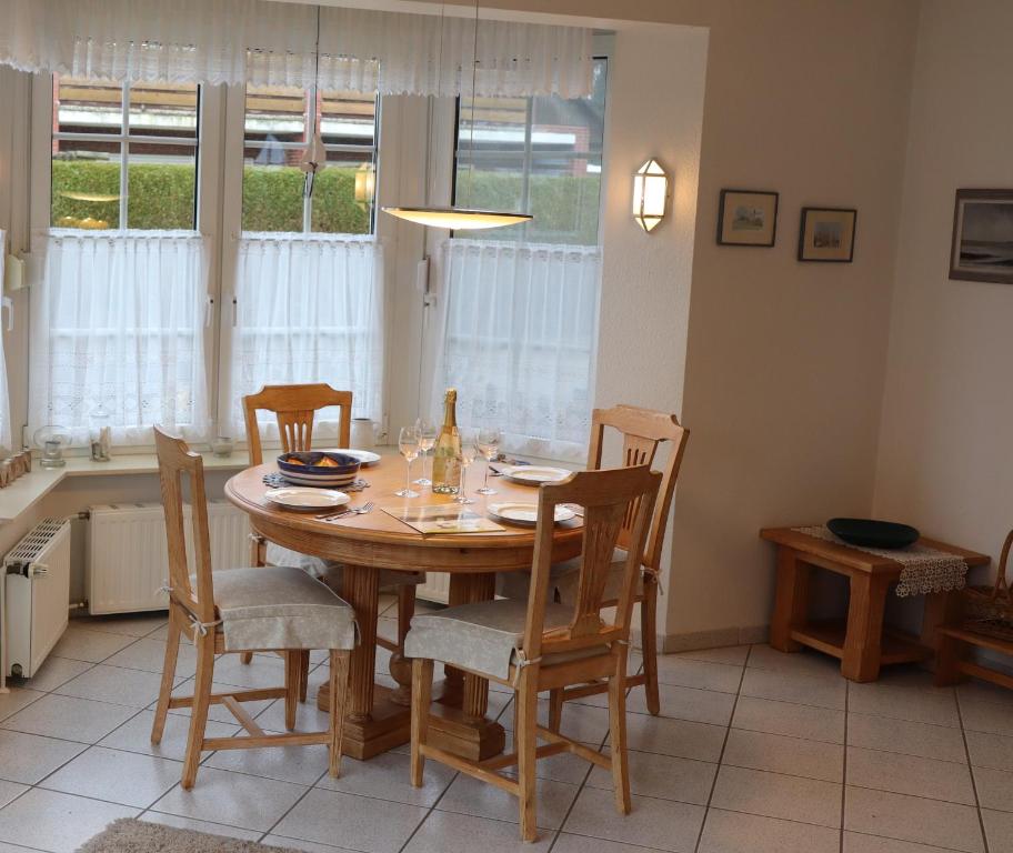 uma sala de jantar com mesa e cadeiras e uma cozinha em Ferienhaus Inselblick em Dornumersiel