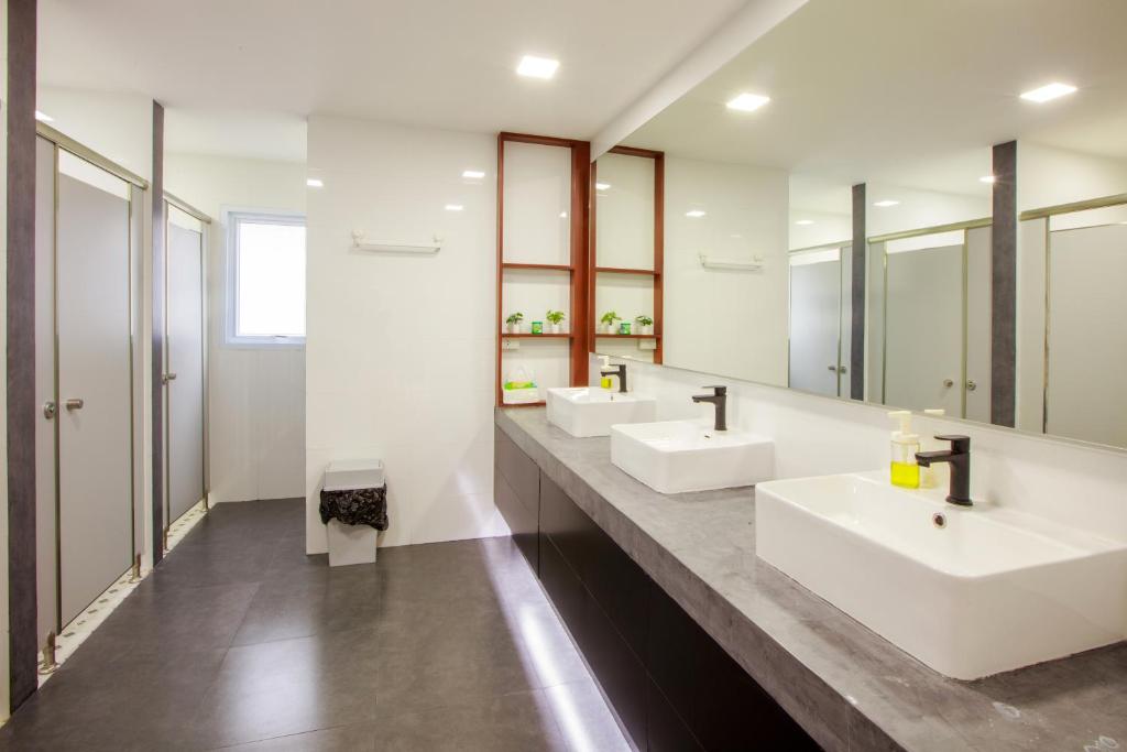 a bathroom with two sinks and two mirrors at Lafami Hostel in Ban Nongdouang