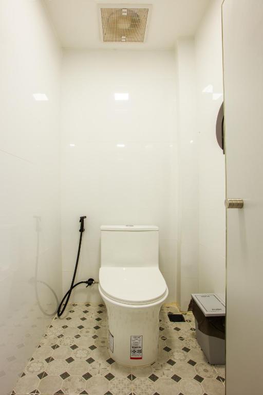 a bathroom with a white toilet in a room at Lafami Hostel in Ban Nongdouang