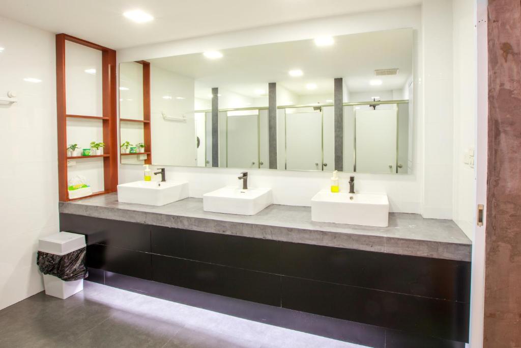 a bathroom with three sinks and a large mirror at Lafami Hostel in Ban Nongdouang