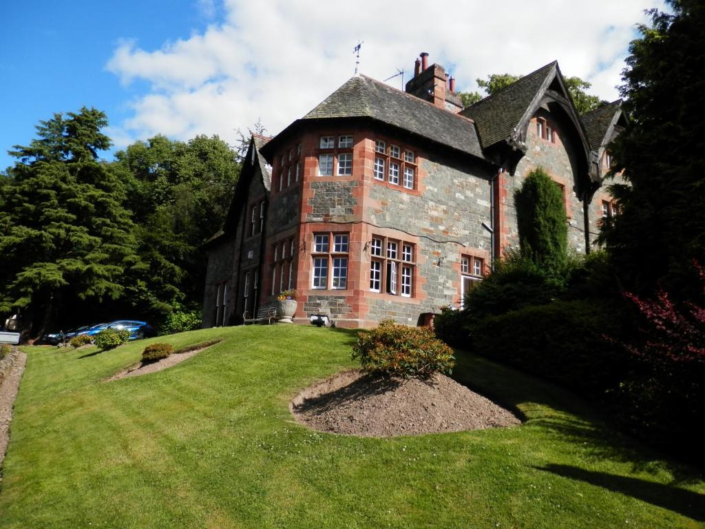 un viejo edificio de ladrillo en una colina de hierba en The Glen Guesthouse, en Selkirk