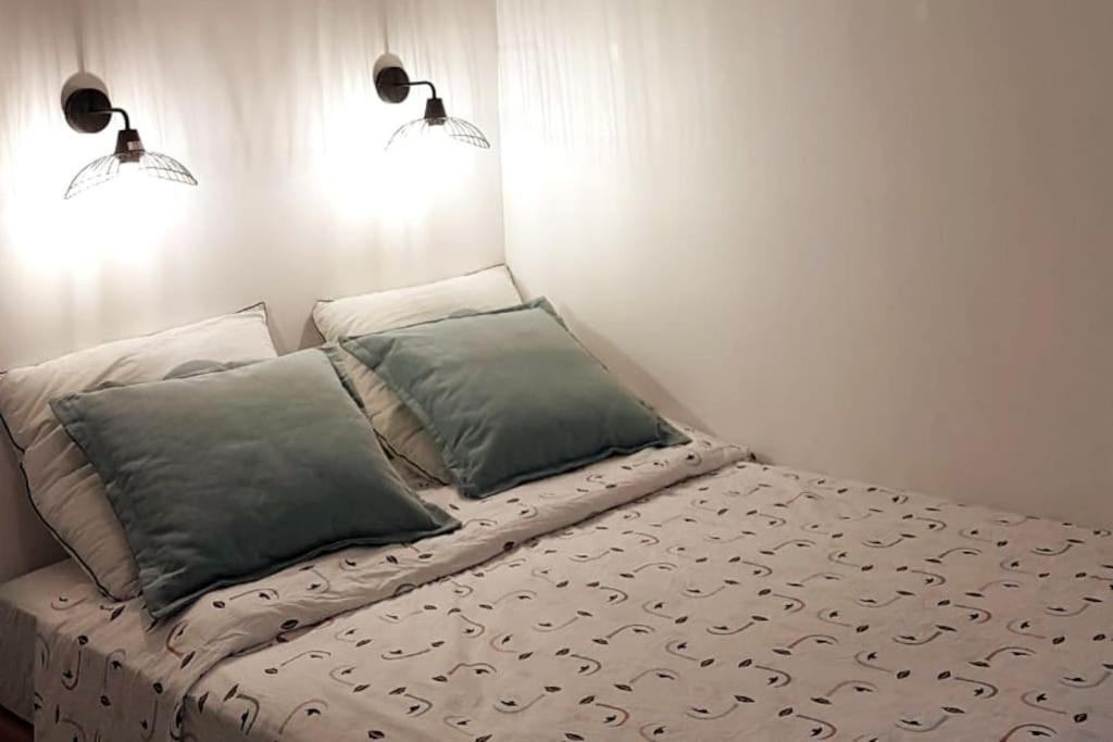 a bed with two pillows on it in a room at Studio cosy, quartier canal Saint-Martin in Paris