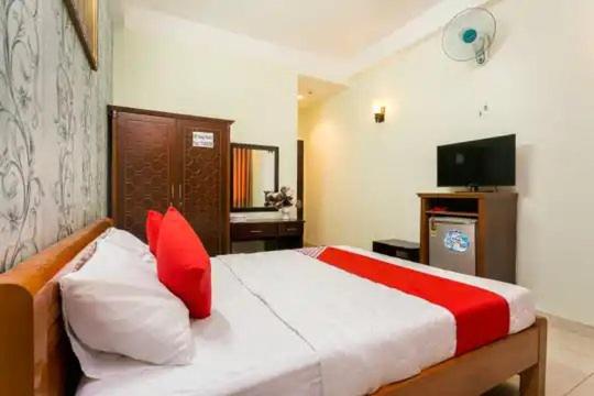 um quarto com uma cama com almofadas vermelhas e uma televisão em Hoàng Yến Nhi Hotel - 36 Đ. Số 51, Gò Vấp - by Bay Luxury em Ho Chi Minh