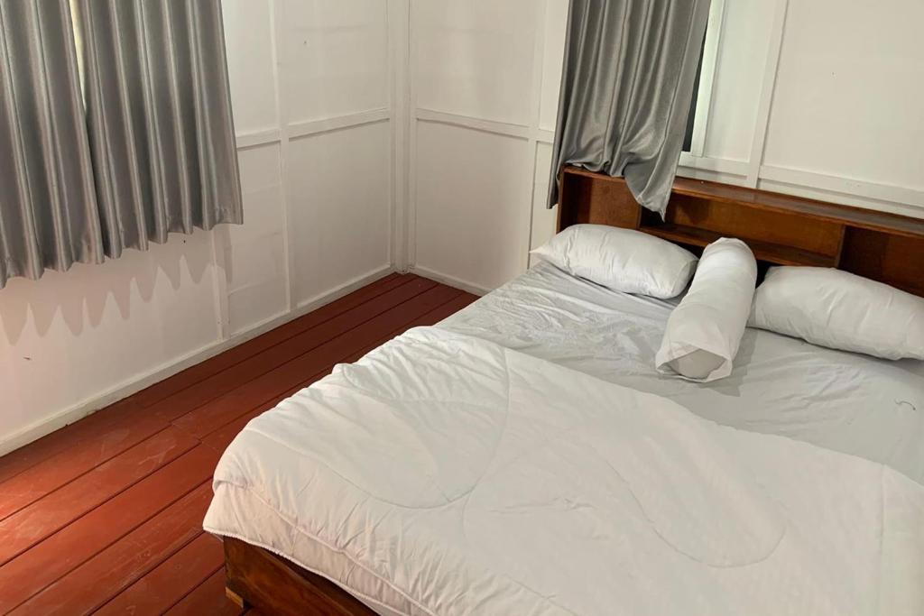 een slaapkamer met een wit bed met 2 kussens bij Capital O 93437 Embung Banteran Cottage in Banyumas