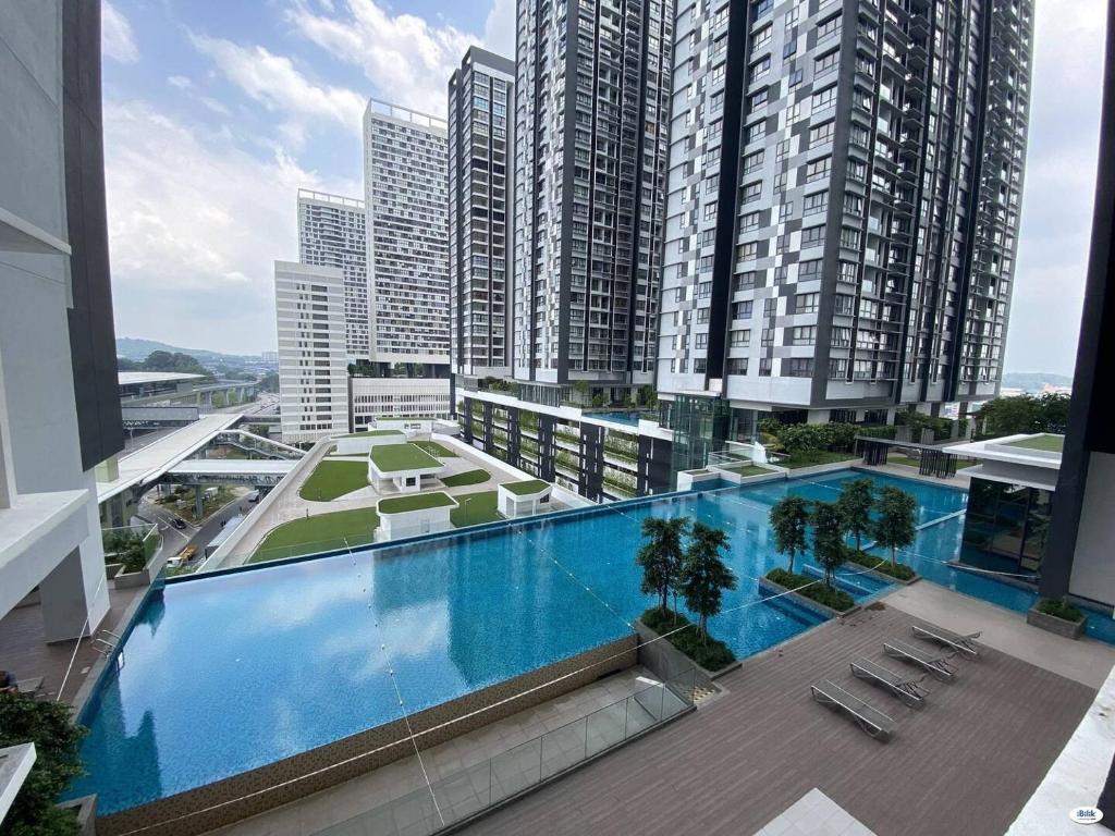 a large swimming pool on top of a building with tall buildings at Fully furnished Studio Unit. in Sungai Buluh