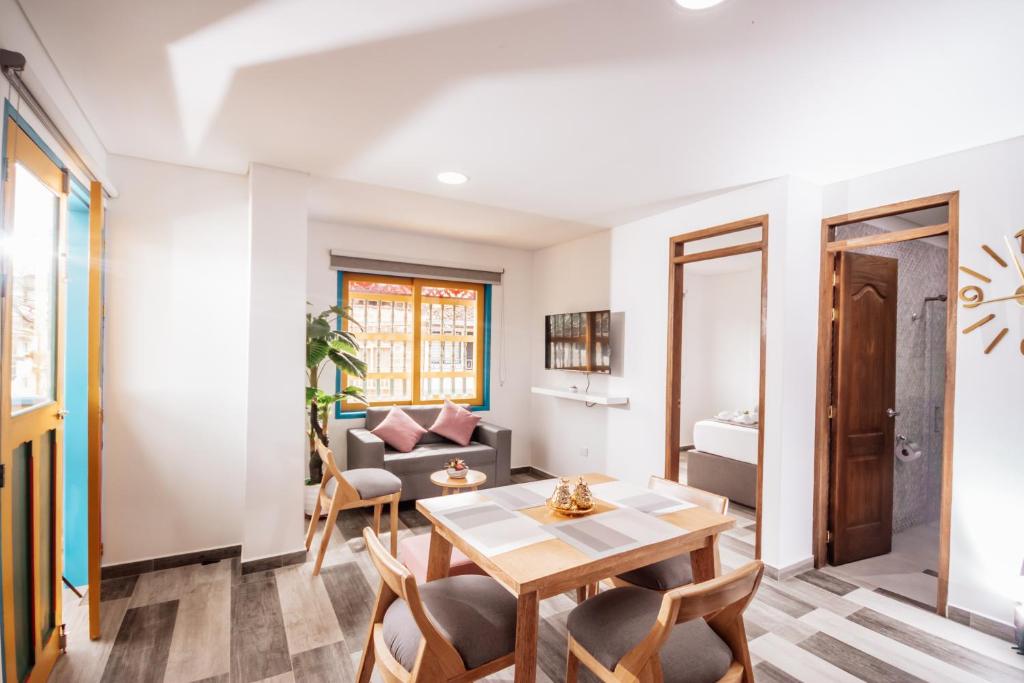 a living room with a table and chairs and a couch at Las Palmas Apartamentos Guatapé in Guatapé