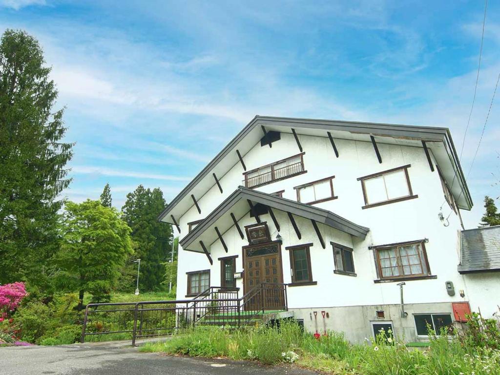 a white house with windows on the side of it at ロッヂ秀岳 in Chikuni