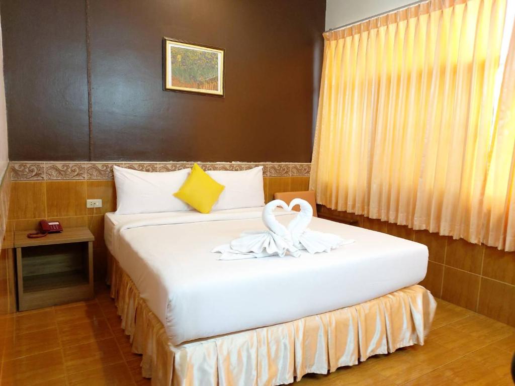 Una habitación de hotel con una cama con una toalla. en Suriwong Chumphon Hotel, en Chumphon