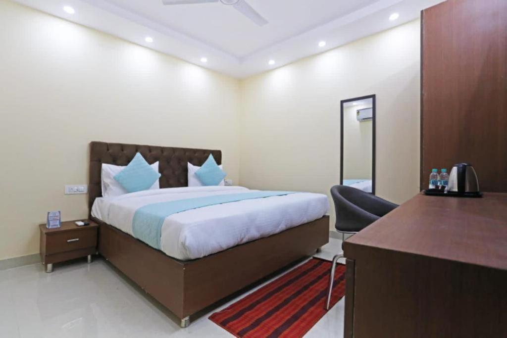 a hotel room with a bed and a desk and a desk at FabHotel Mannat Paschim Vihar in New Delhi