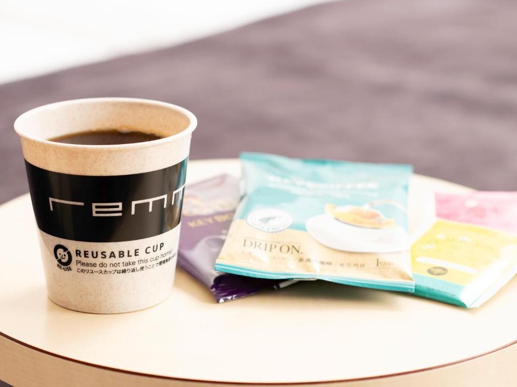 a cup of coffee and a book on a table at remm plus Kobe Sannomiya in Kobe