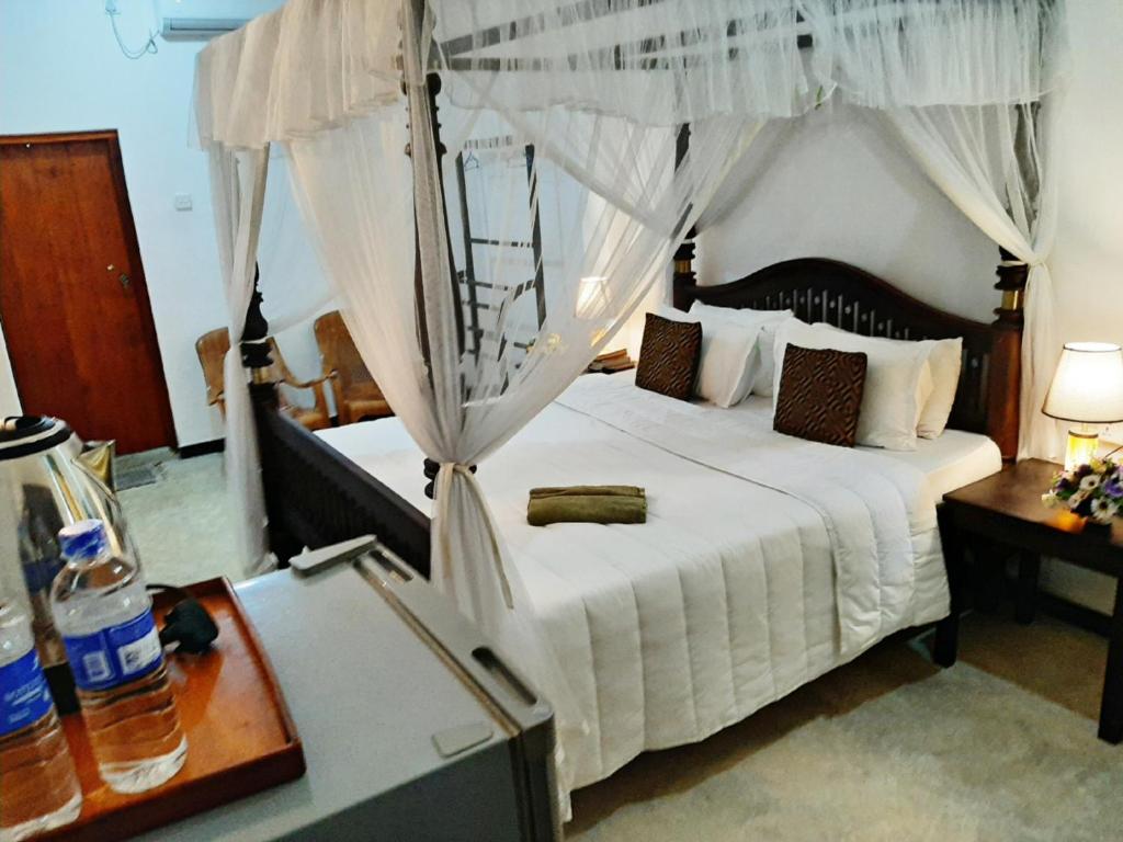 a bedroom with a large white bed with a canopy at Villa Blue Ocean in Mirissa