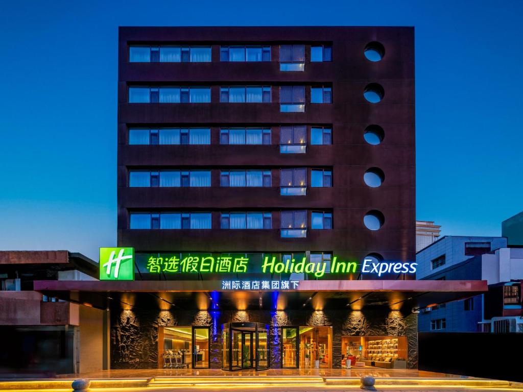 um edifício alto com um sinal em frente em Holiday Inn Express Lanzhou Zhengning Road, an IHG Hotel em Lanzhou