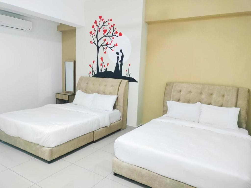duas camas sentadas uma ao lado da outra num quarto em FREE WIFI-FI Travelers HomestySitiawan 5-8pax The Venus Aparment em Seri Manjung