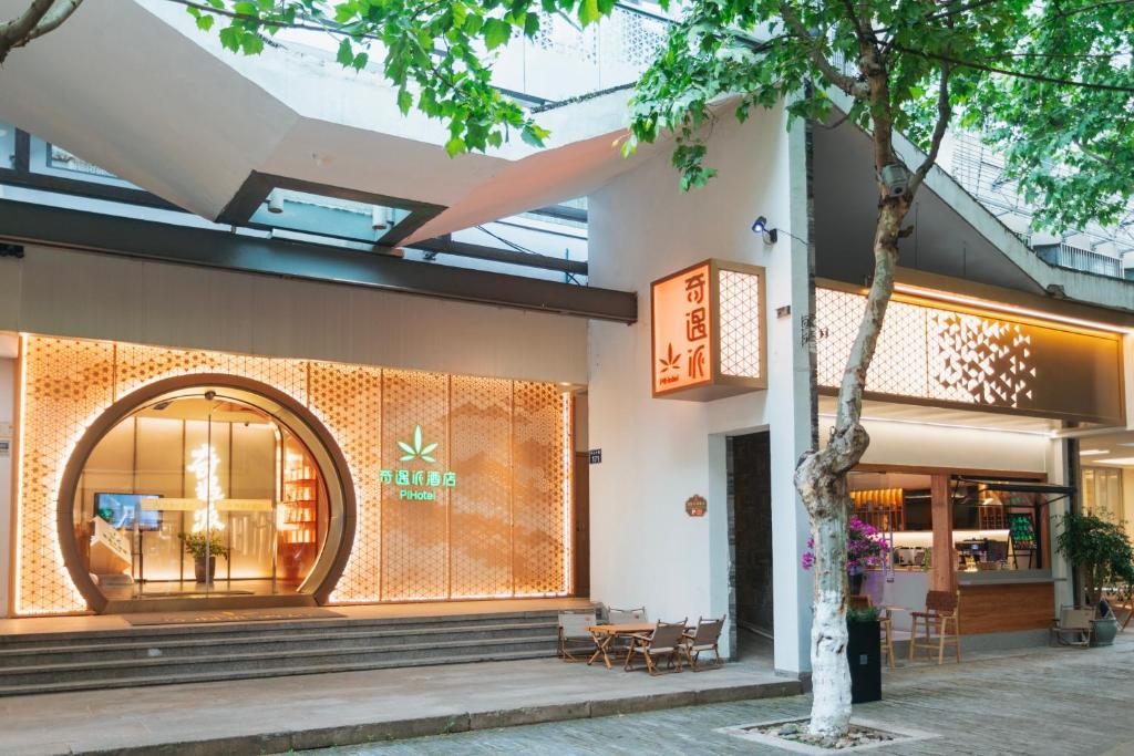 a store front of a building with a tree at Encounter Hotel - West Lake Hefang Street in Hangzhou