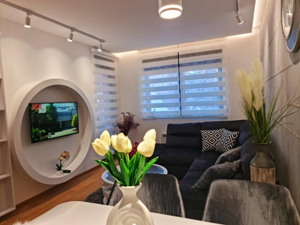uma sala de estar com um sofá e uma mesa em Lux apartman central 48- vila Pekovic em Zlatibor