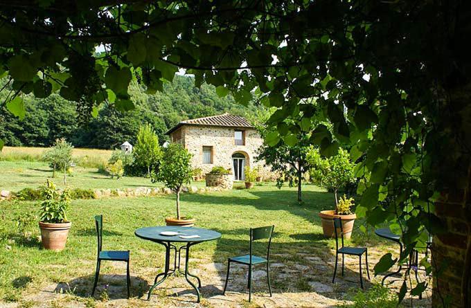 uma mesa e cadeiras num quintal com uma casa em Podere Campalfi em Stigliano