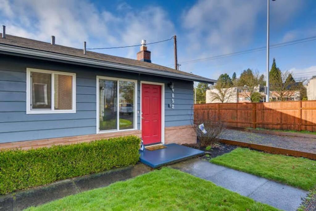 a blue house with a red door in a yard at Beautiful 2 Bedroom Unit w/ FAST FREE WIFI in Beaverton
