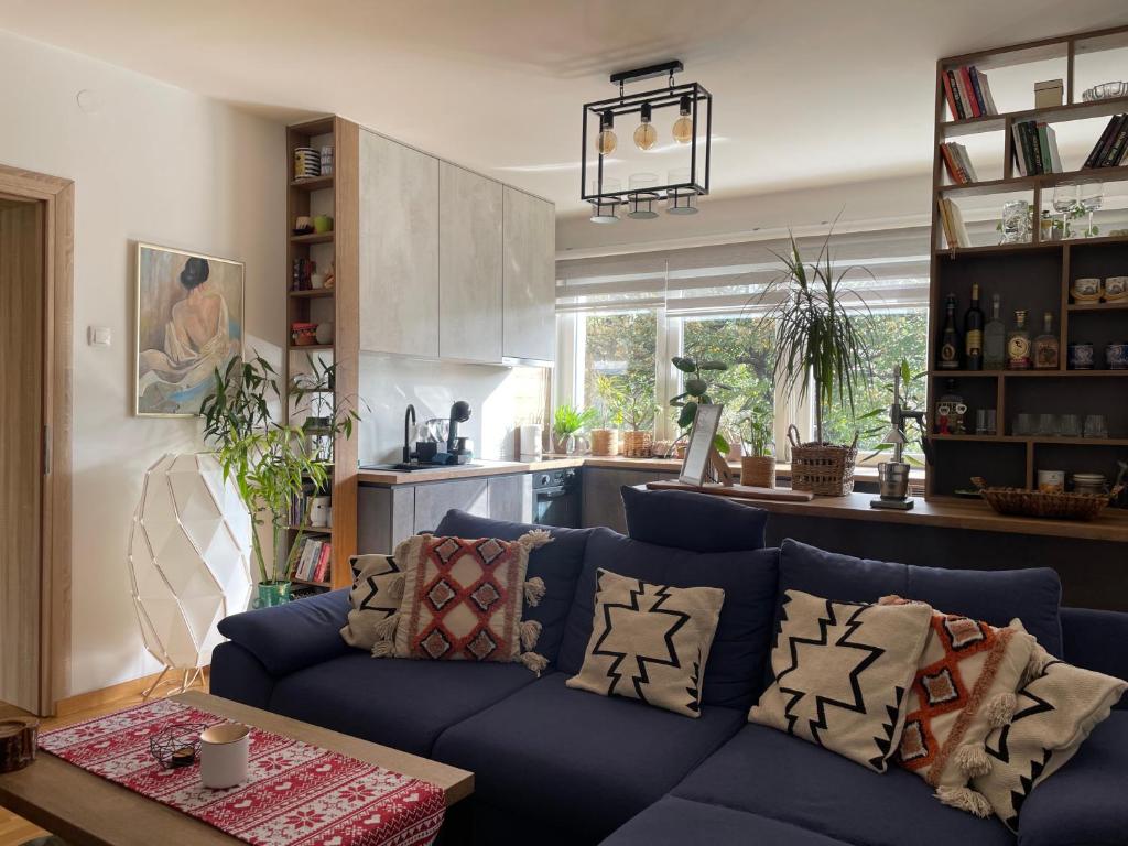 een woonkamer met een blauwe bank en een keuken bij Wild Green in Sarajevo