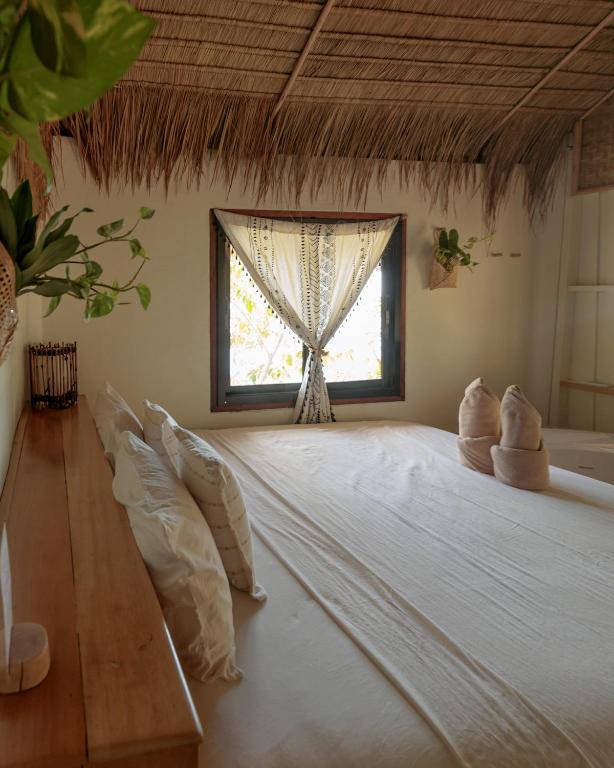 a large bed in a room with a window at Why Nam Beach in Haad Yuan