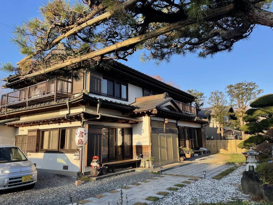 忍野村的住宿－民宿富島 Tomijima Hostel-Traditional japapnese whole house with view of mt fuji - Oshino Hakkai，前面有停车位的房子