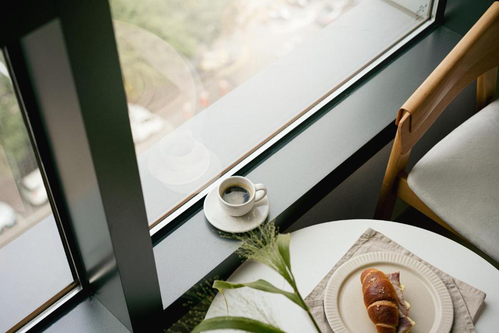 una mesa con un plato de comida y una taza de café en Urbanstay Myeongdong, en Seúl
