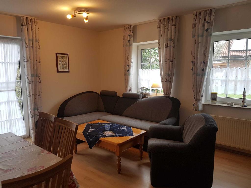 a living room with a couch and a table at Terrassenwohnung Langeoog in Hooksiel