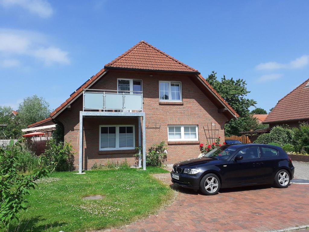 a black car parked in front of a house at Terrassenwohnung Strandlust in Hooksiel
