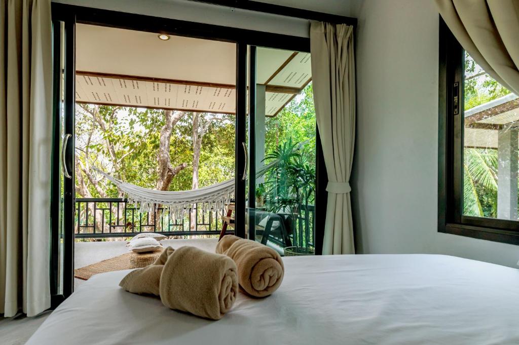 a bedroom with a bed and a large window at Why Nam Beach in Haad Yuan