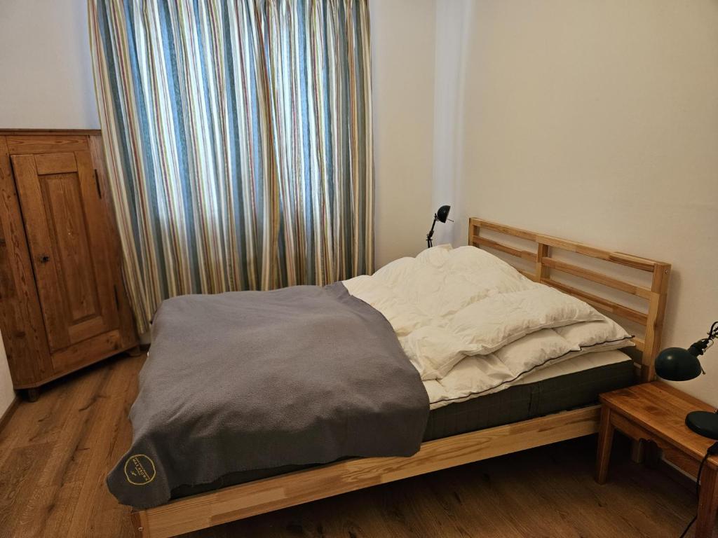 1 dormitorio con cama con marco de madera y ventana en Ferienhaus Birnberg, en Leogang