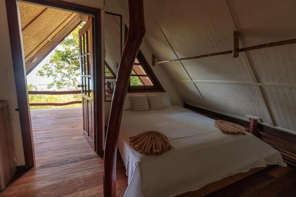 a bed in a room with a large window at Why Nam Beach in Haad Yuan