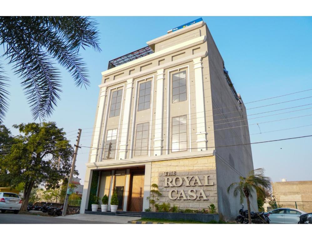 a tall white building with a sign on it at The Royal Casa Hotel, Ludhiana in Ludhiana