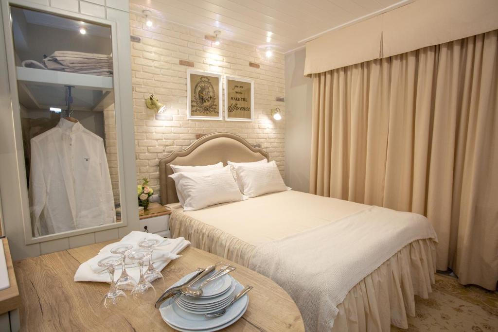 Un dormitorio con una cama y una mesa con platos. en Aelia Luxury Apartments, en Ioannina
