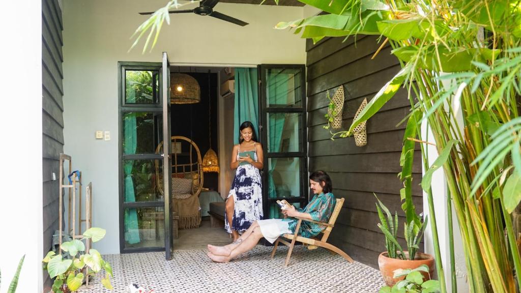 two women sitting in chairs on the porch of a house at El Nido Boutique Vacation Villas in El Nido
