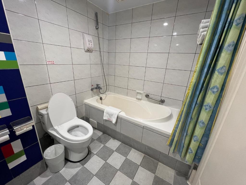 a bathroom with a toilet and a bath tub at King&#39;s Resort &amp; Spa in Tai&#39;an