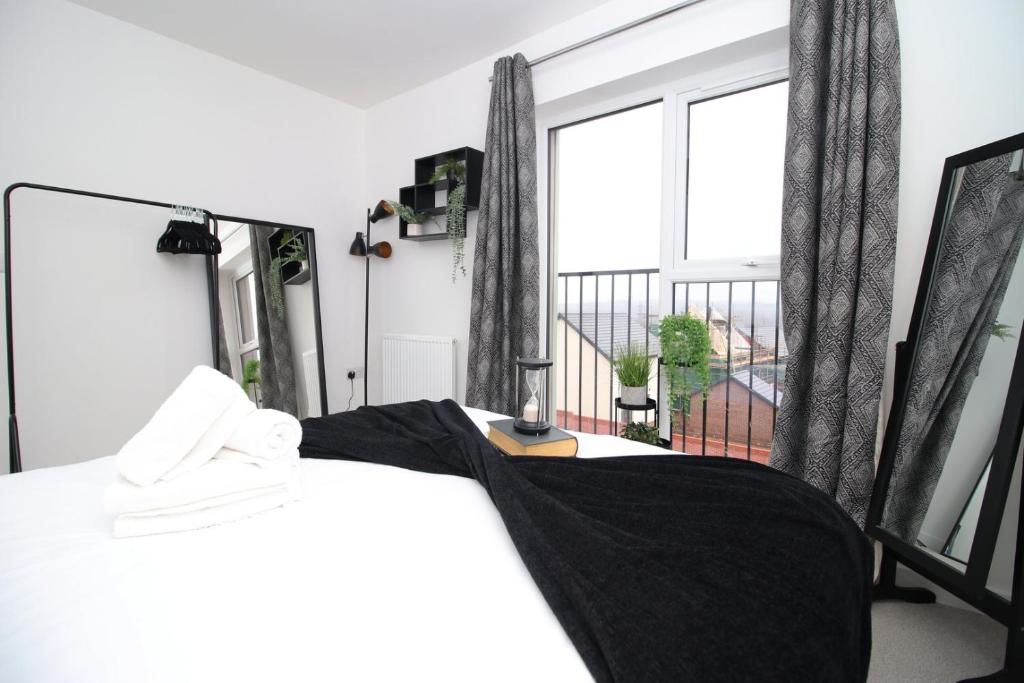 a bedroom with a bed and a large window at Church Road Cardiff FREE parking in Cardiff