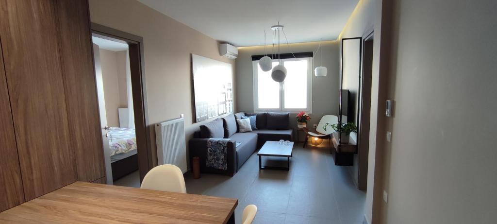 ein Wohnzimmer mit einem Sofa und einem Tisch in der Unterkunft AERIAL NEST in Thessaloniki