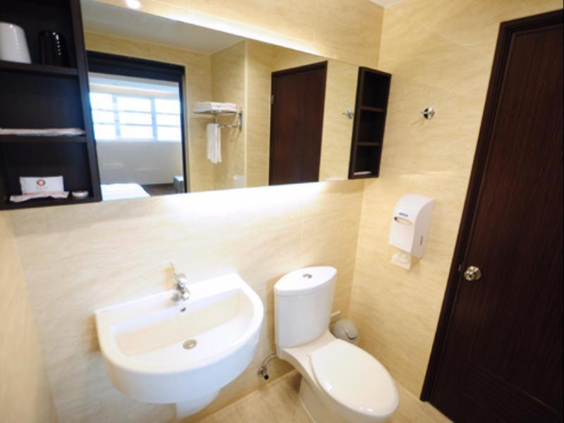 a bathroom with a white toilet and a sink at Kindness Hotel-Qixian in Kaohsiung