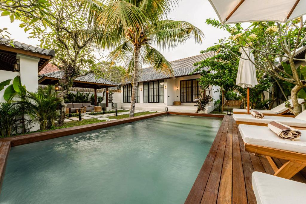 een overloopzwembad in de achtertuin van een villa bij Hijau Villa by EVDEkimi Ubud in Ubud