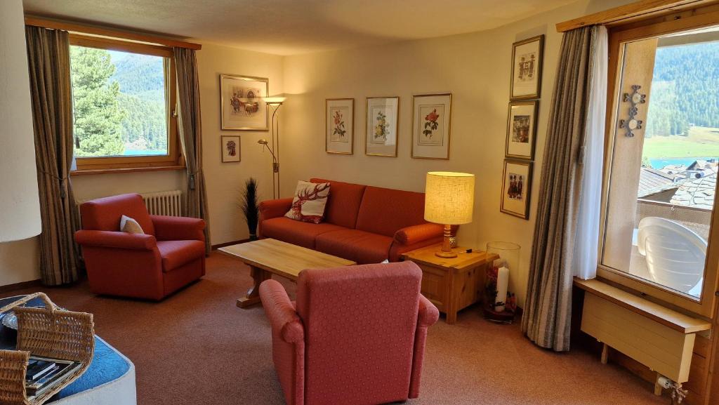 Una sala de estar con un sofá y sillas y una mesa. en Chesa Bellaval, Haus Rizza 2-Zimmerwohnung, en Silvaplana