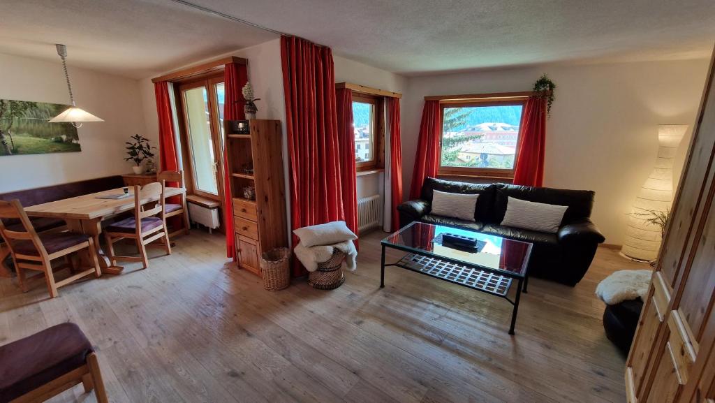 un soggiorno con divano e tavolo di Chesa Bellaval, Haus la Vuolp 2 1 2-Zimmerwohnung a Silvaplana