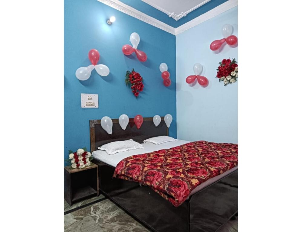 um quarto com uma cama com balões vermelhos e brancos na parede em Hotel Abhi Jawalamukhi, Himachal Pradesh em Jawāla Mukhi
