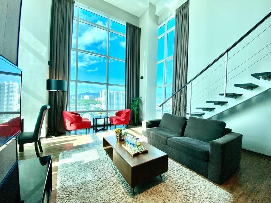 a living room with a couch and a table at Maritime Suite - Seaview Modern Luxury Duplex Suite in Jelutong