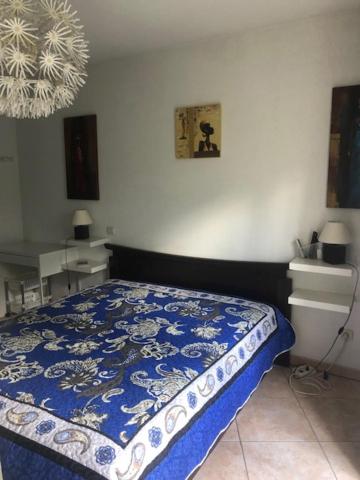 a bedroom with a bed with a blue and white comforter at Chez Peter in La Grande Motte