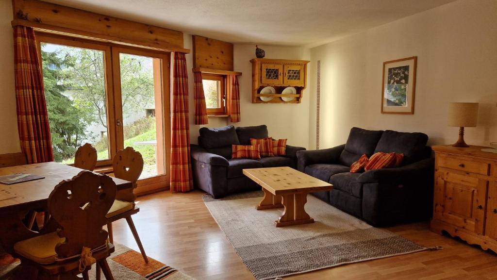 ein Wohnzimmer mit einem Sofa und einem Tisch in der Unterkunft Chesa Bellaval, Haus Leivra 2 1 2-Zimmerwohnung in Silvaplana