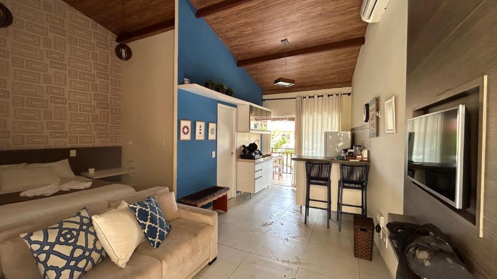 ein Wohnzimmer mit einem Sofa und einer Küche in der Unterkunft Loft Solar Água in Pipa