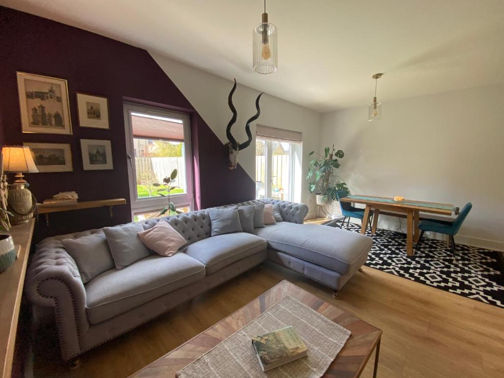 a living room with a couch and a table at Modern Home Near Edinburgh City in Bonnyrigg