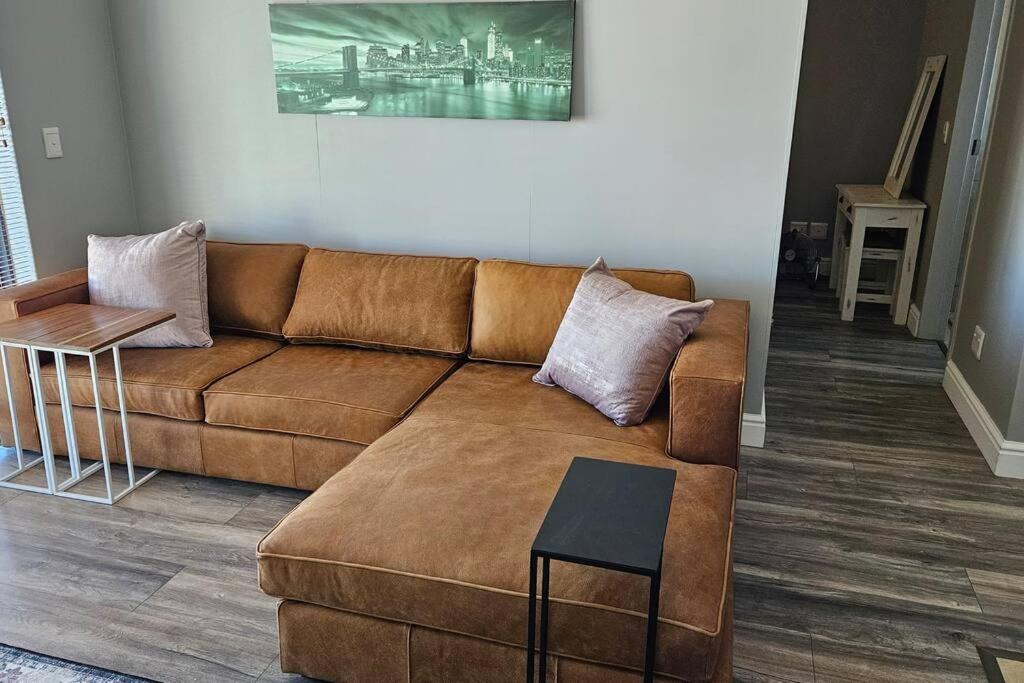 a living room with a brown couch and a table at SS Luxury Apartments in Cape Town